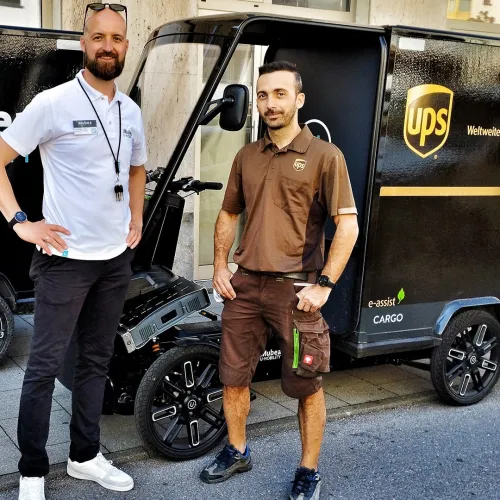 Two young persons standing in front of eCargo Bikes, one of them branded with UPS.