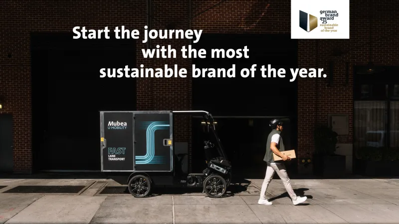 Delivery eCargo Bike in front of wall with text: Start the journey with the most sustainable brand of the Year in Germany.